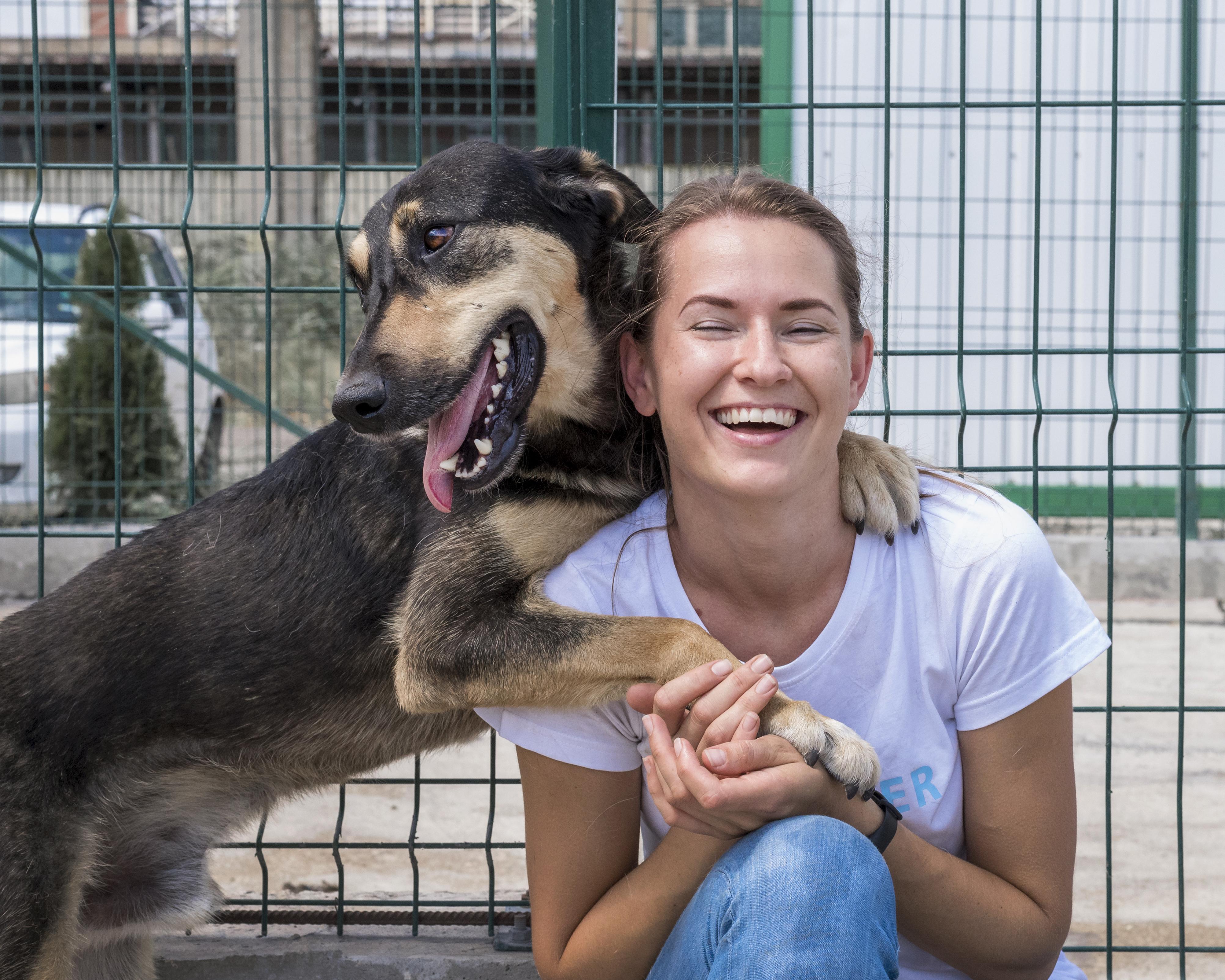 files/smiley-woman-playing-shelter-with-dog-waiting-be-adopted.jpg