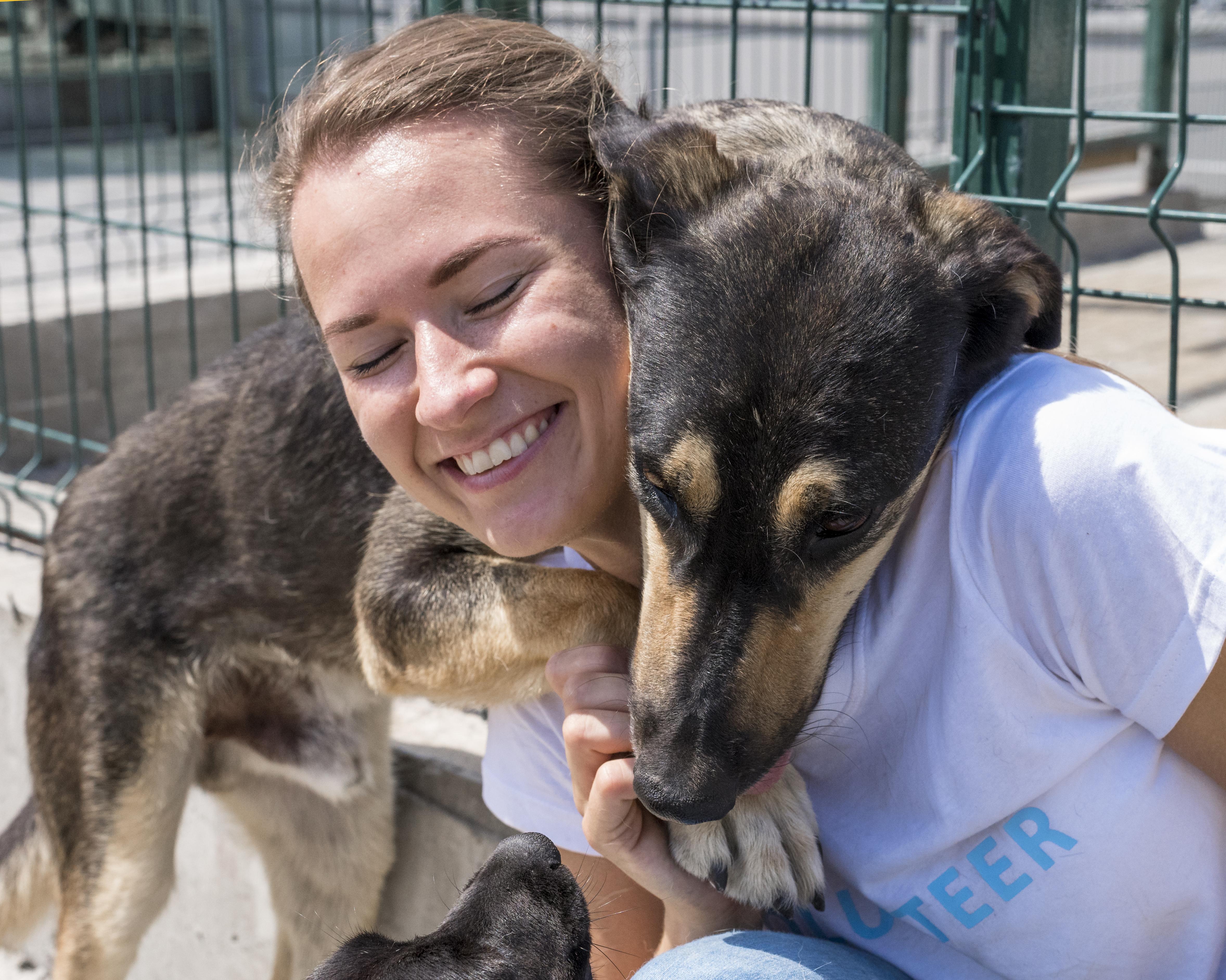files/smiley-woman-playing-with-cute-dog-up-adoption.jpg